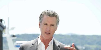 Man speaking with microphone outdoors.