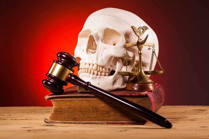 A skull, gavel, and scales of justice on a book against a dark background