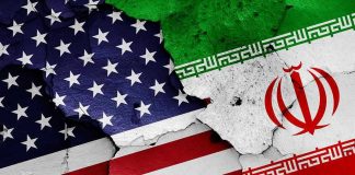 Cracked American and Iranian flags on a wall.