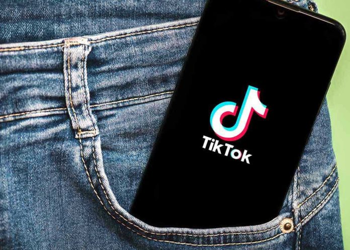 1920422882 Phone with TikTok logo in jeans pocket.