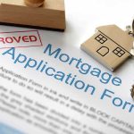 Approved mortgage application form with a house key and keychain