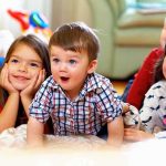 A group of children enjoying playtime indoors, displaying joyful expressions