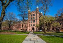 Yale Professor OUSTED After Emails EXPOSED Historic university building surrounded by green grass and trees under a blue sky