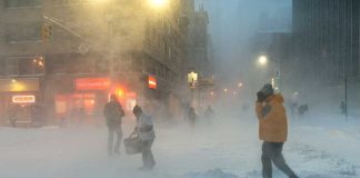 People walking in a snowy urban street during a blizzard