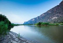 River with mountains and greenery in the background.