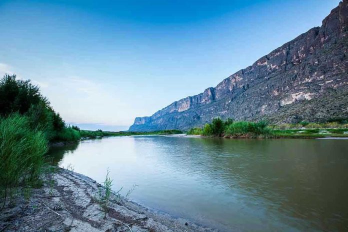 River with mountains and greenery in the background.