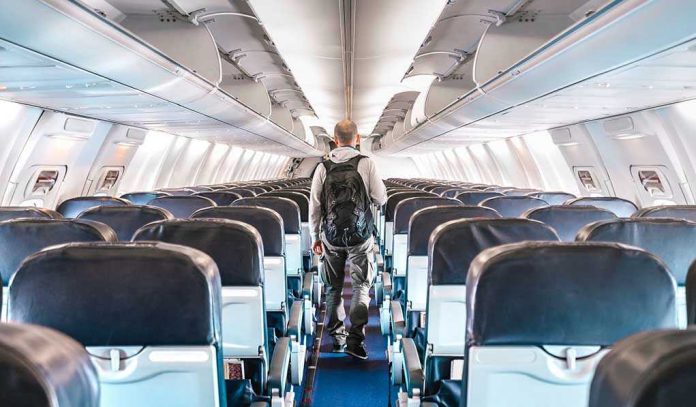 1664709973 Person walking down empty airplane aisle