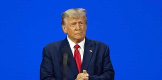 Man in a suit with a blue background.