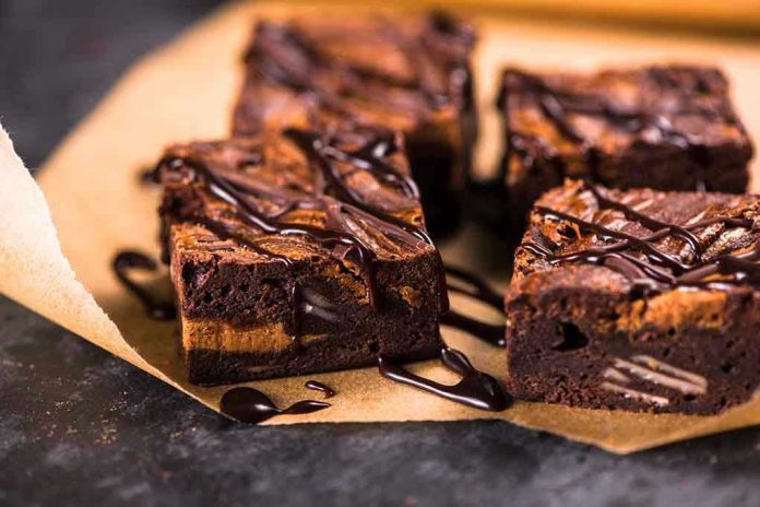 Chocolate brownies with drizzled chocolate on parchment paper.