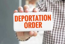 Hand holding sign with Deportation Order text.