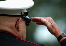 109-Year-Old WWII Hero Stuns Mound A veteran in military uniform saluting with a hand raised