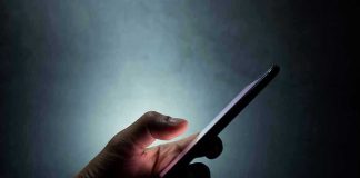 Indiana SLAMS Digital Predators With Major Penalties Hand holding a smartphone in the dark.