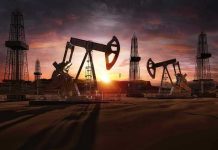 Oil rigs operating at sunset in a desert landscape.