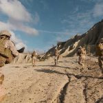 Soldiers running on rocky terrain with backpacks.