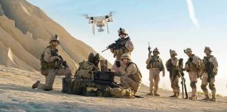 Soldiers operating a drone in a desert environment.