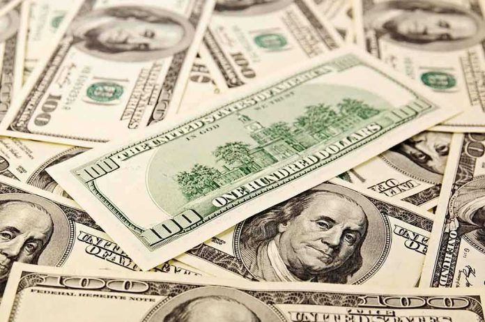 A collection of hundred dollar bills scattered on a surface