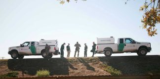 Trumps Top Chief QUITS Amid Scandal Border Patrol vehicles and agents on a ridge.