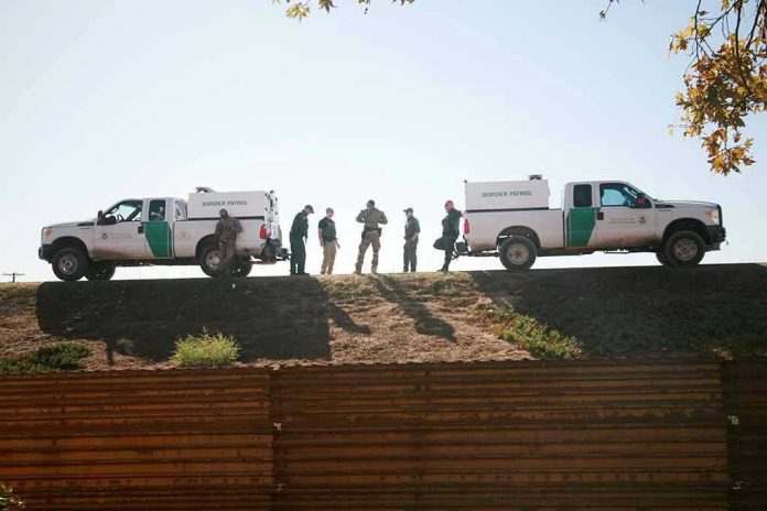 1243518340-1 Border Patrol vehicles and agents on a ridge.
