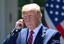 Trump’s Shocking Health Revelation: Fatal Diagnosis Man in a suit adjusting an earpiece.