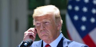 Trump’s Shocking Health Revelation: Fatal Diagnosis Man in a suit adjusting an earpiece.
