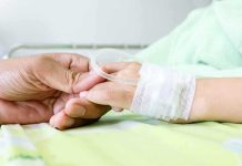 E. Coli Outbreak ROCKS Beloved Restaurant Chain! A person holding the hand of a patient with an IV in a hospital bed