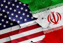 Iran To Receive Billions After Deal Announced! Cracked American and Iranian flags on a wall.