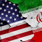 Cracked American and Iranian flags on a wall.