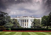 Trump Team SCRAMBLES – Situation Room Tapes LEAKED! White House front view with dark clouds above.