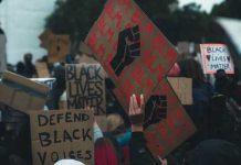 Crowd holding Black Lives Matter signs at a protest.