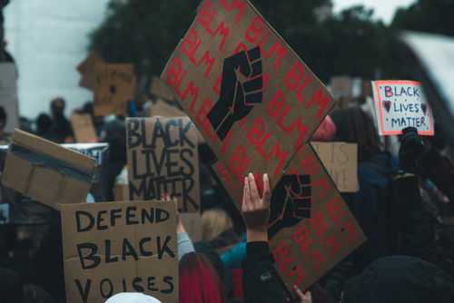 Crowd holding Black Lives Matter signs at a protest.