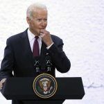 Biden Left Wondering During Dem Event A man in a suit speaking at a podium with a presidential seal