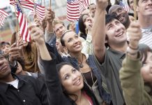 Joy Reid Torches July 4 – Backlash Erupts! A diverse group of people joyfully waving American flags in celebration