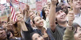 Joy Reid Torches July 4 – Backlash Erupts! A diverse group of people joyfully waving American flags in celebration