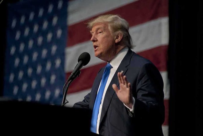 shutterstock_787487767 man in suit speaking at a podium with a US flag backdrop