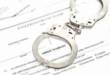 Plane Hijacker Awaiting Deportation RELEASED by Activist Judge Handcuffs on top of an arrest warrant document.