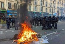 Molotov Horror ERUPTS Outside Police HQ Fire burning on the street amid police presence.