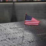 9/11 Families Demand Muslim Mayor STAY AWAY American flag on a rainy memorial nameplate.