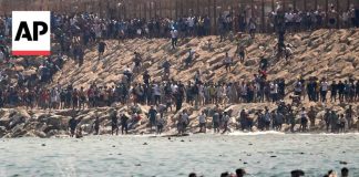Thousands of migrants swim around the border from Morocco into Ceuta, Spain