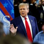 Midnight War: Trump Goes on Expletive Rant! A man in a suit with a red tie speaking at a political event