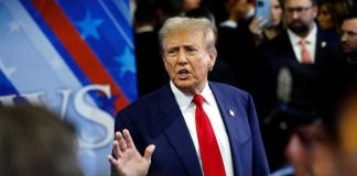 Midnight War: Trump Goes on Expletive Rant! A man in a suit with a red tie speaking at a political event