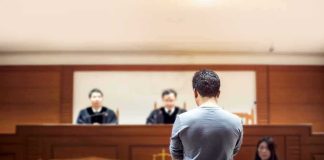 Convict SWAPS Gender Last-Minute Sparking Legal Uproar defendant stands before judges in a courtroom