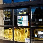 Store entrance with yellow shopping carts behind glass doors