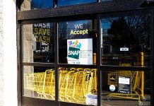 Store entrance with yellow shopping carts behind glass doors