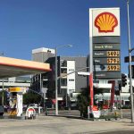 Gas Prices SKYROCKET As Conflict Escalates Shell gas station with price sign on a sunny day