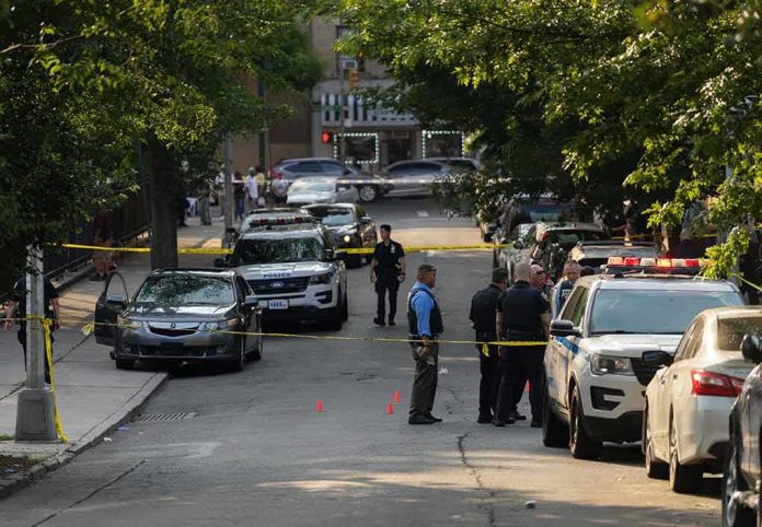 Police officers secure a residential street with patrol cars and yellow tape