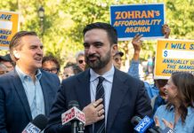 Mamdani SABOTAGES Historic 60-Year Tradition! A politician speaking at a rally with supporters holding signs