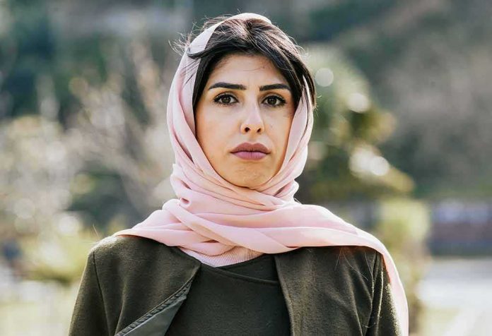 shutterstock_1355164223 Woman in a pink headscarf outdoors
