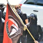 Antifa Mob STORMS Church, Attack Conservative Star Masked protesters holding a black and red flag