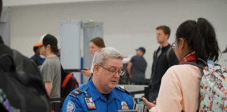 ICE Gate Arrests Spark Airport Showdown tsa officer checks a traveler's documents at airport security