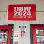 red political banner above two red doors on a storefront